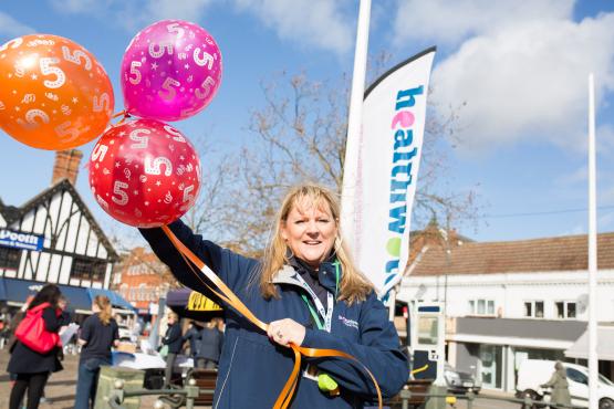 Volunteer holding balloons at event