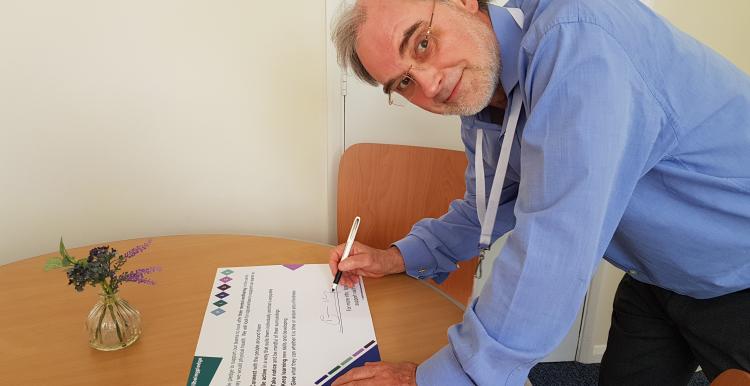 David N Jones, Chair of Healthwatch Northamptonshire, signing the wellbeing pledge.