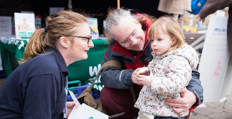 Healthwatch Volunteer talking to a little girl and her dad