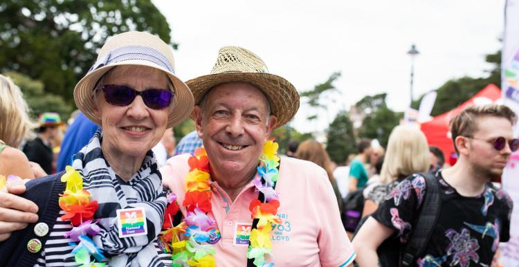Older people smiling at camera at pride event