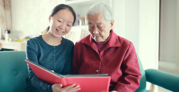 Two women reading together in a care home