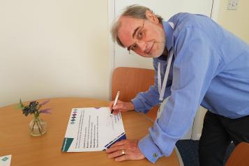 David N Jones, Chair of Healthwatch Northamptonshire, signing the wellbeing pledge.