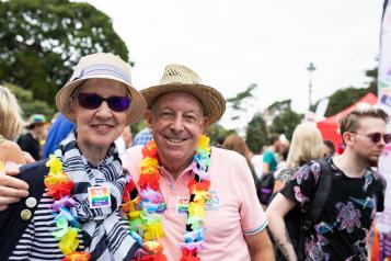 Older people smiling at camera at pride event
