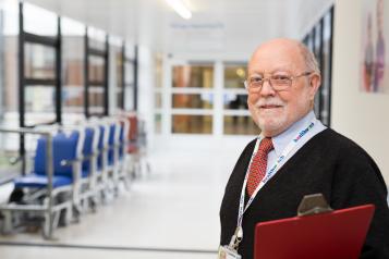 Older male Healthwatch volunteer with clipboard at hospital