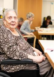 Older women wheelchair user at table with pen