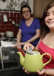 A young female carer helping her mum in the kitchen