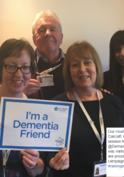 Volunteers and staff holding an "I'm a dementia friend" sign